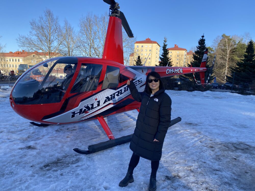 Ella beside a helicopter in Finland