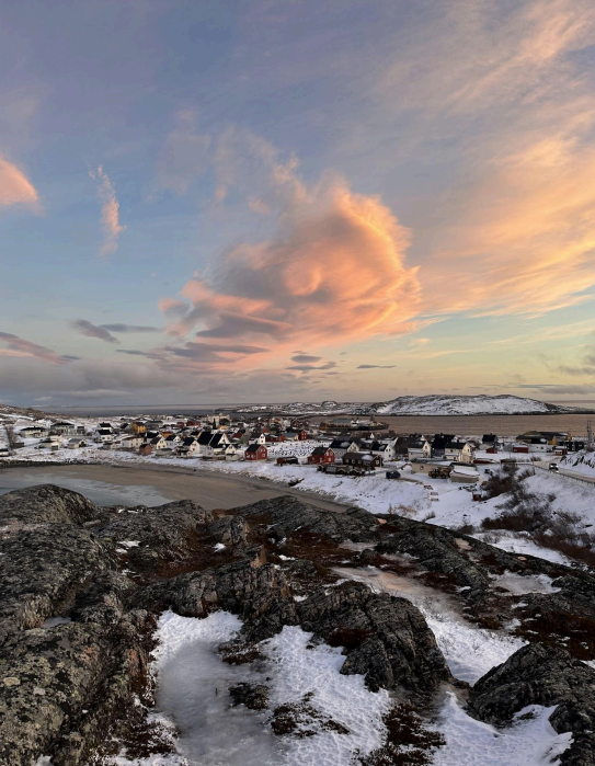 A snowy beach landscape overlooking the village of Bugøynes in Finnmark.